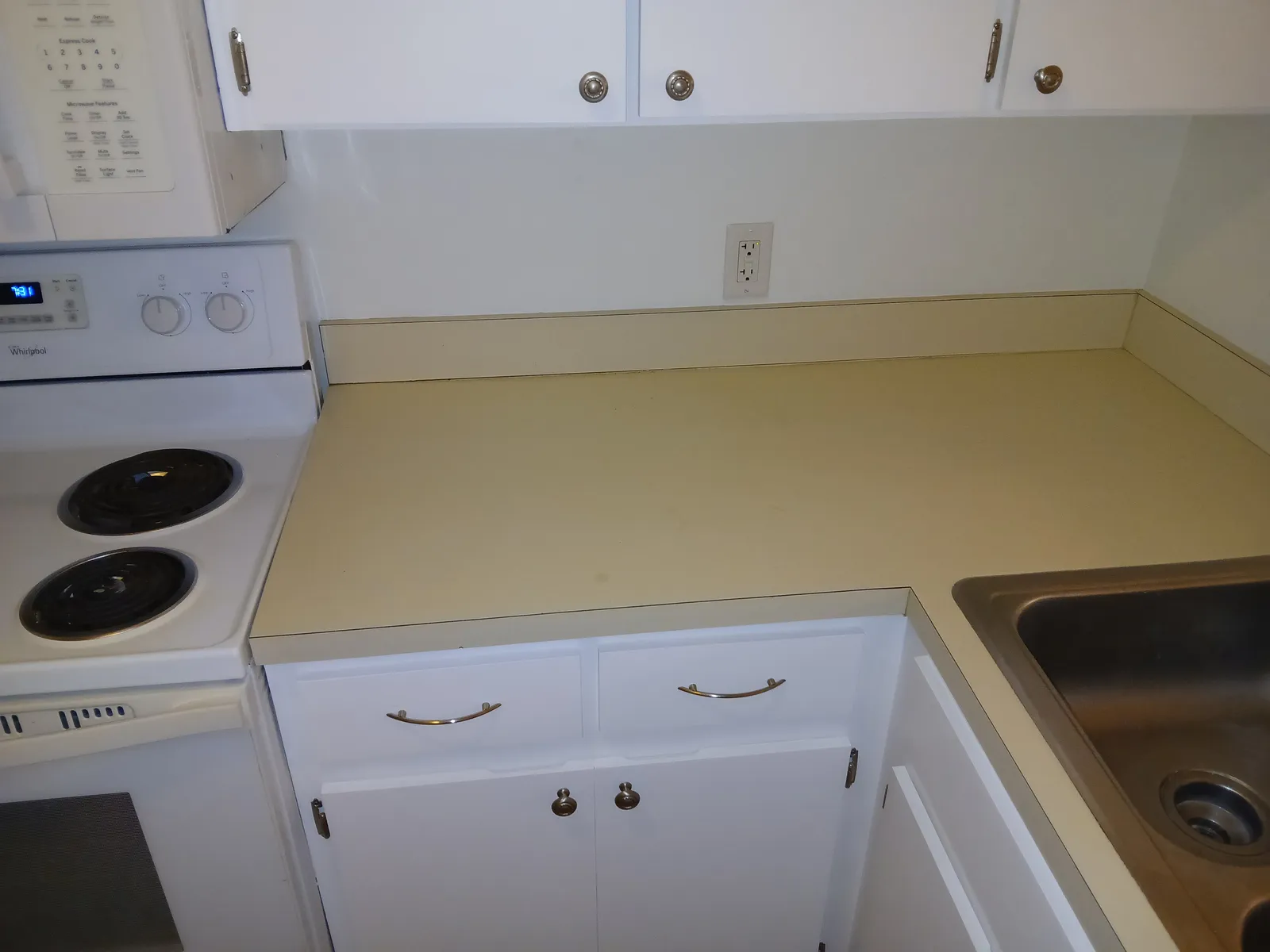 The same kitchen corner with the cabinets painted white